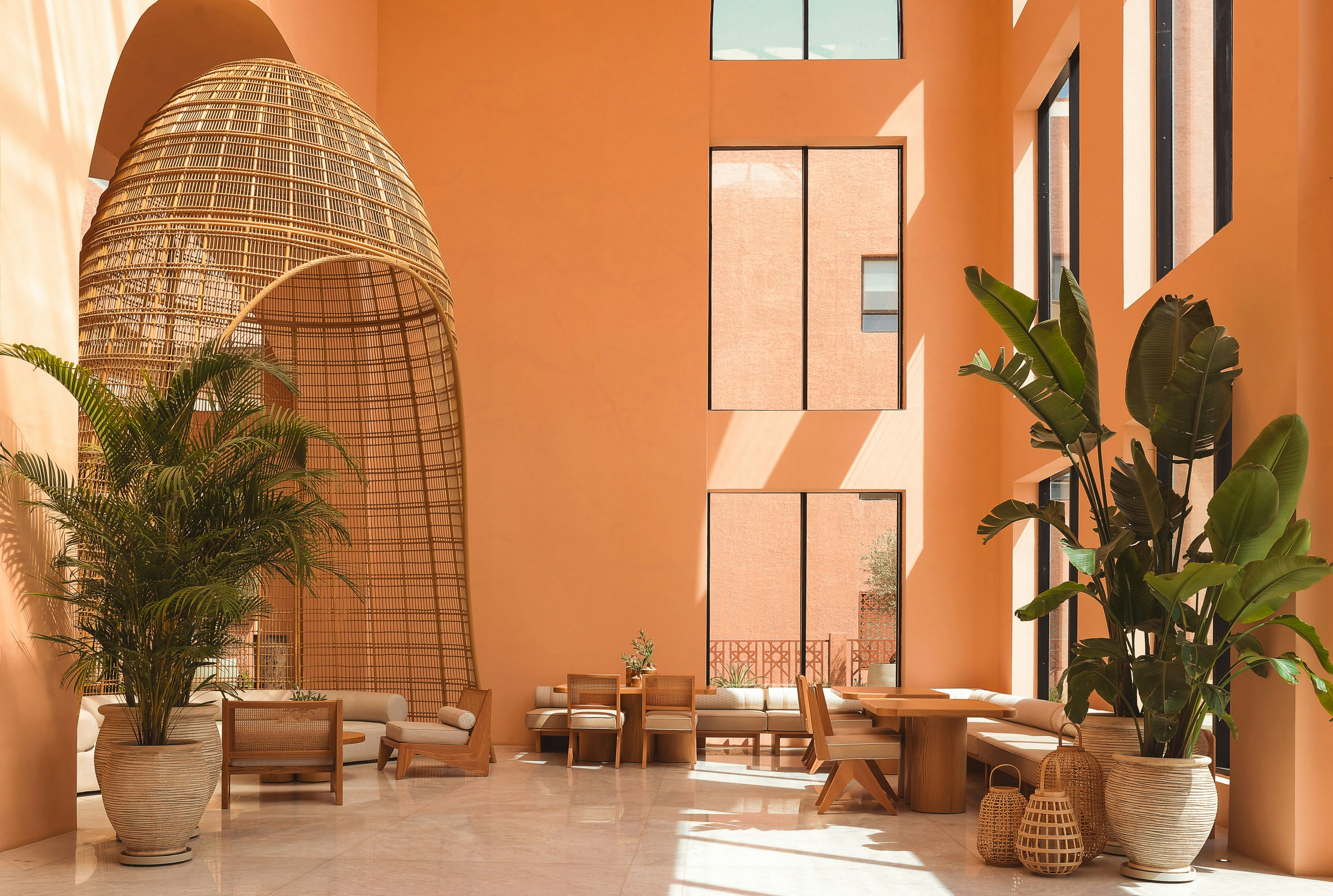 A semi enclosed hut, tables, and plants in a luxury apartment lobby