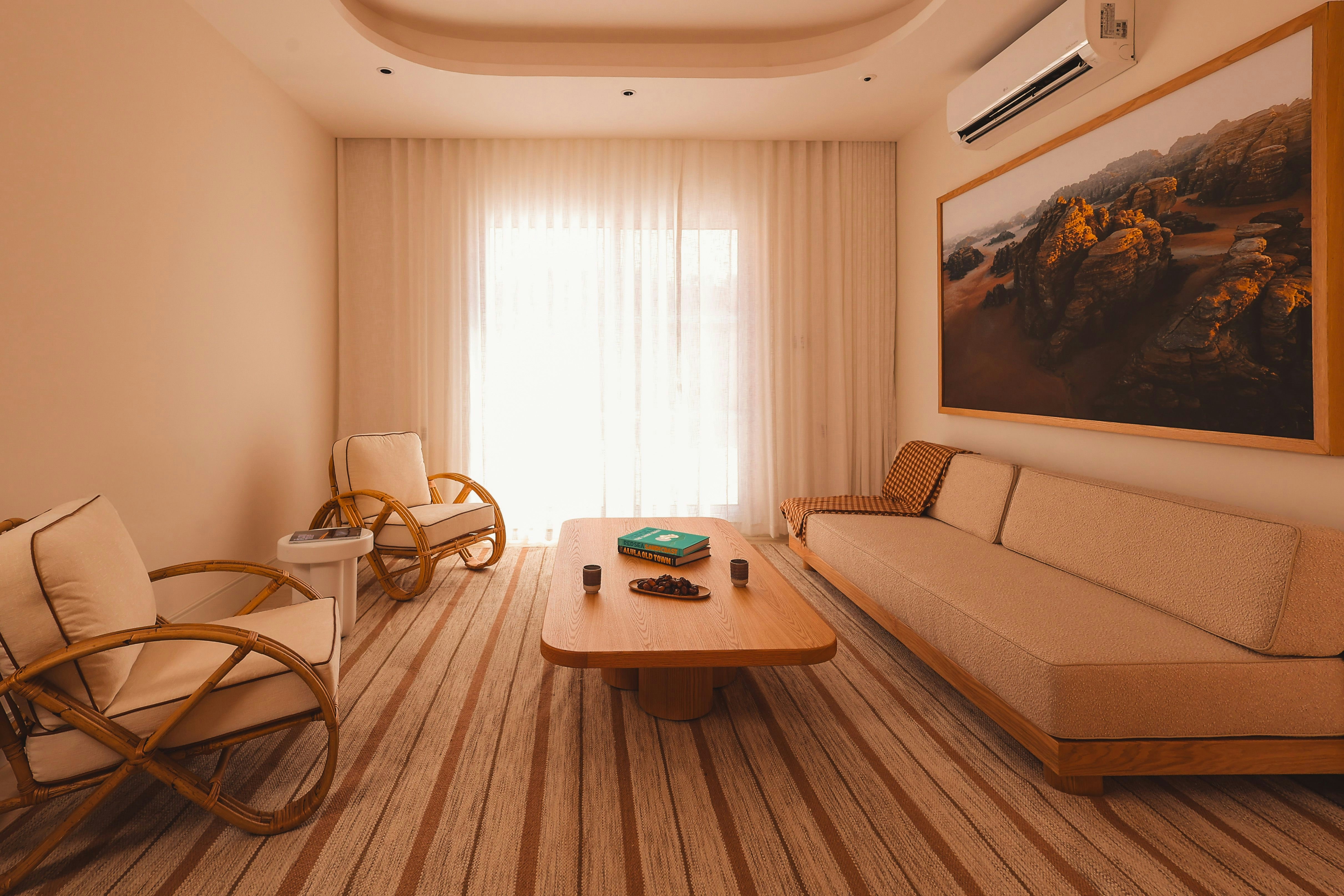 A luxury apartment living room with two chairs, a sofa, a coffee table, and canyon artwork on the wall