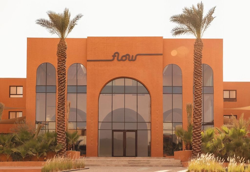 Entryway to Flow Narjis apartments flanked by two palm trees